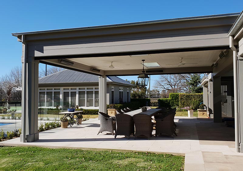 Patio with long table and chairs featuring folded a patio blinds