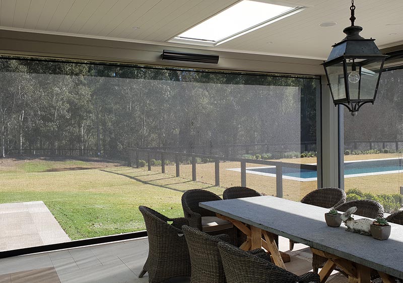 Patio with long table and chairs featuring folded a patio blinds