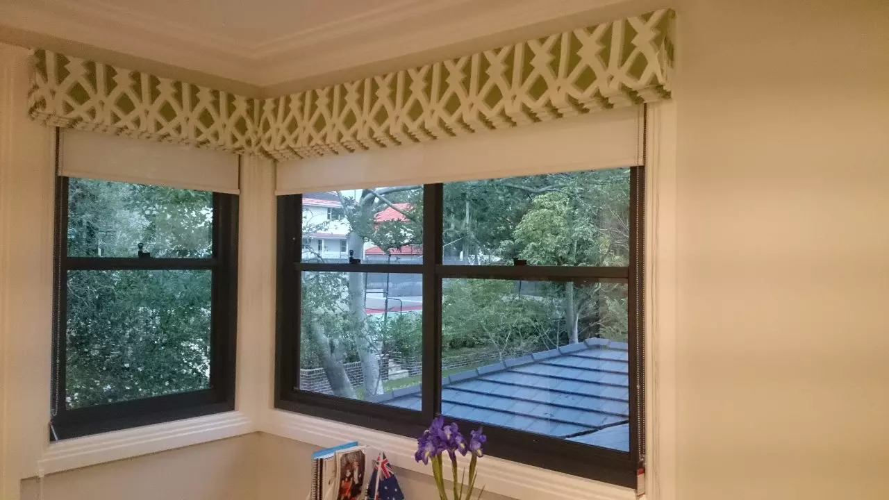 Green and white color of roman blinds that have been folded.